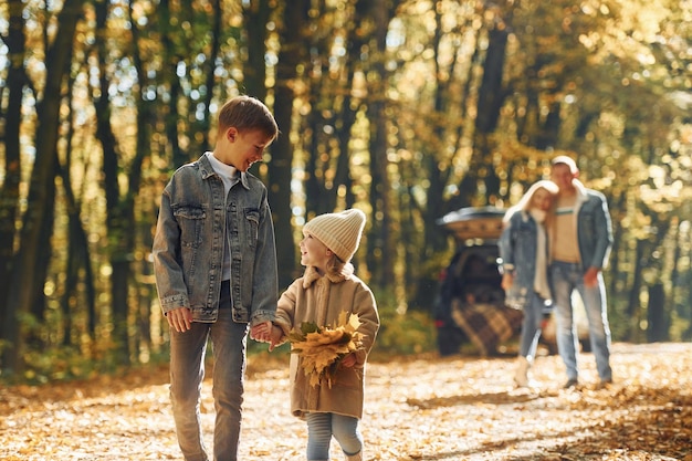 Sister with brother walking Happy family is in the park at autumn time together