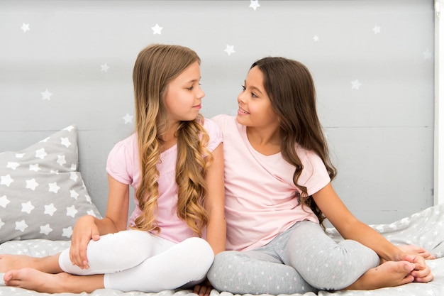 Sisters or best friends spend time together in bedroom Girls having fun together Girlish leisure Sisters friends share gossips having fun at home Pajamas party for kids Siblings best friends
