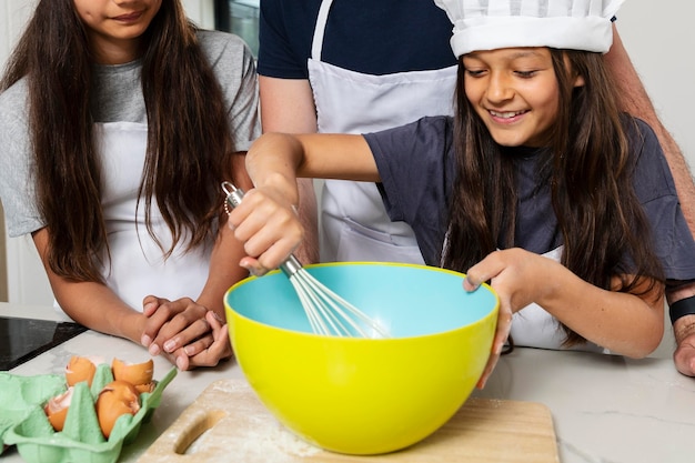 Photo sisters cooking in the kitchen with their father