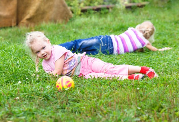 Sisters playing in the meadow with Ball