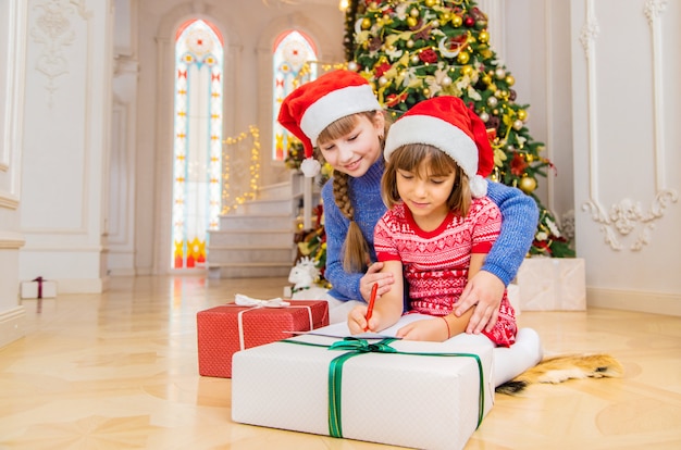 The sisters write a letter to Santa. Selective focus.