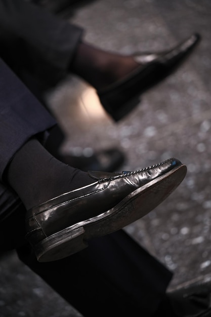 A sit man with moccasin cross his legs during a meeting