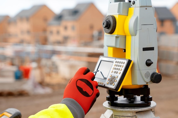 Photo site engineer in hiviz working on house building construction site using modern surveying equipment