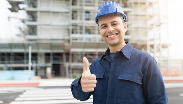 Site manager giving thumbs up in front of a construction site