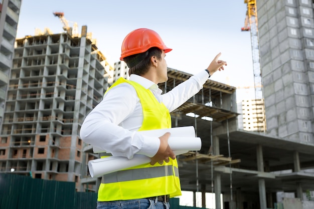 site manager in helmet checking building site under construction