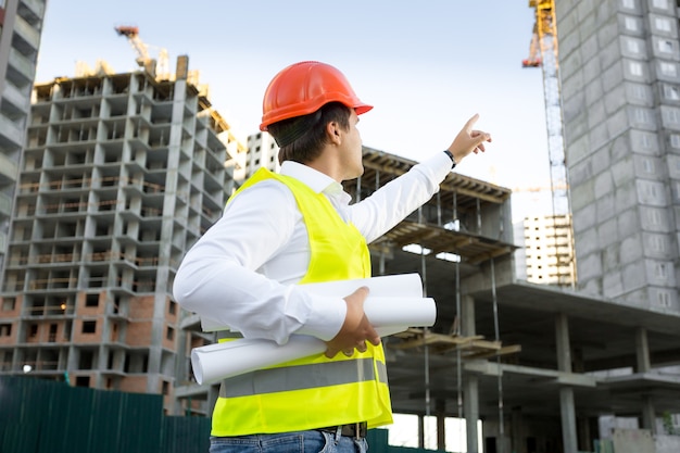 Site manager in helmet checking building site under construction