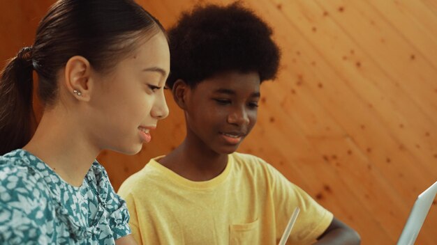 Photo site view of african boy and girl working together to code prompt edification