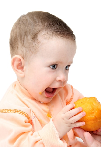 Sitting baby eating peach