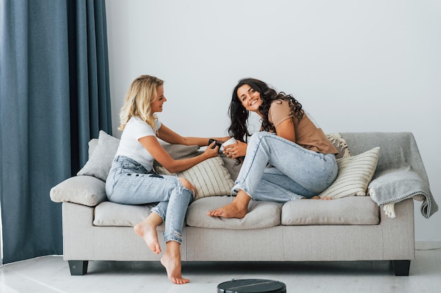 sitting on bed two women is together at home