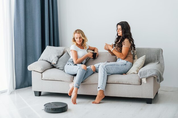 sitting on bed two women is together at home