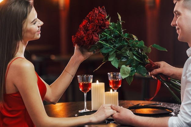 Sitting by the table Romantic couple have dinner in the restaurant