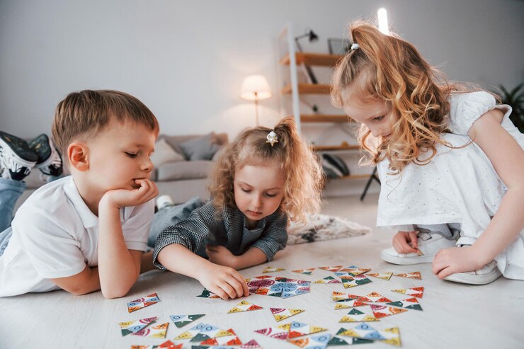 Photo sitting on the floor and playing game group of children is together at home at daytime