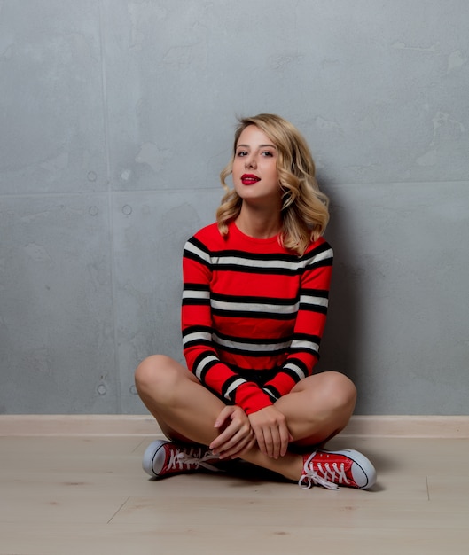 빨간 줄무늬 스웨터에 앉아있는 여자