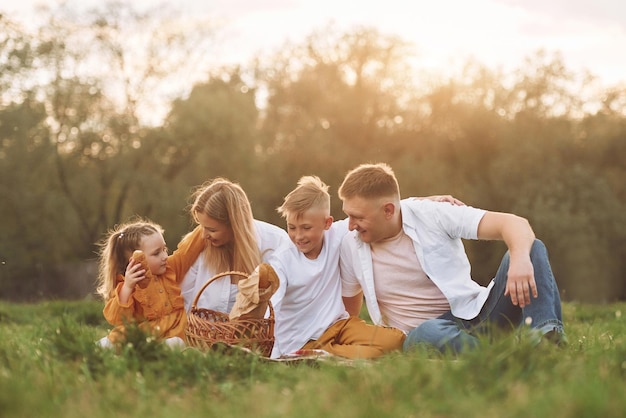 Sitting on the green grass Family have weekend outdoors at summertime together