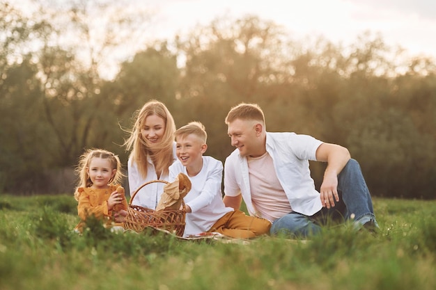 Sitting on the green grass Family have weekend outdoors at summertime together