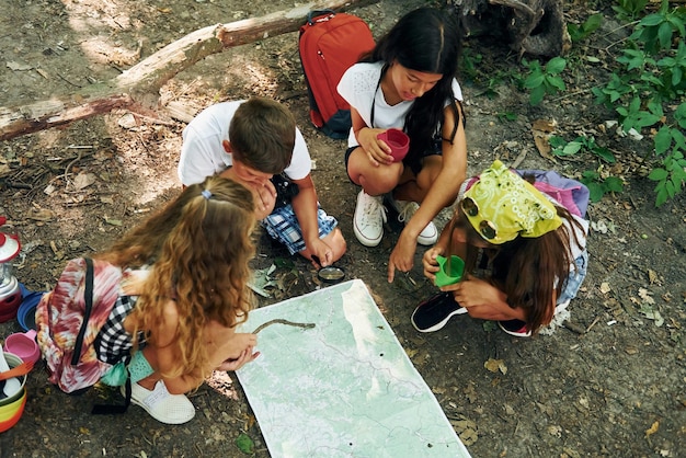 Sitting on the ground Kids strolling in the forest with travel equipment