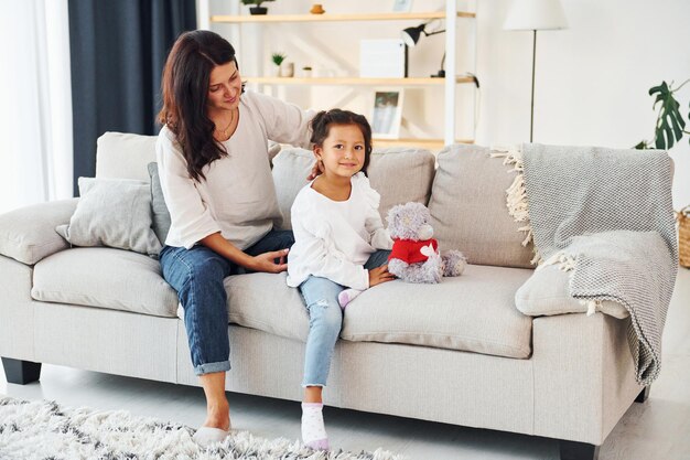 Sitting on the sofa Mother and her daughter spending time together at home