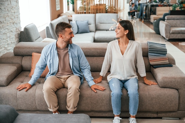 Sitting and testing product Couple choosing the sofa and bed in the store