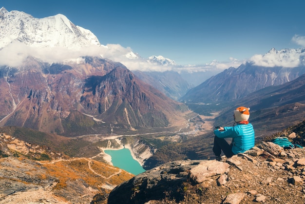 Sitting woman against beautiful lake and mountains