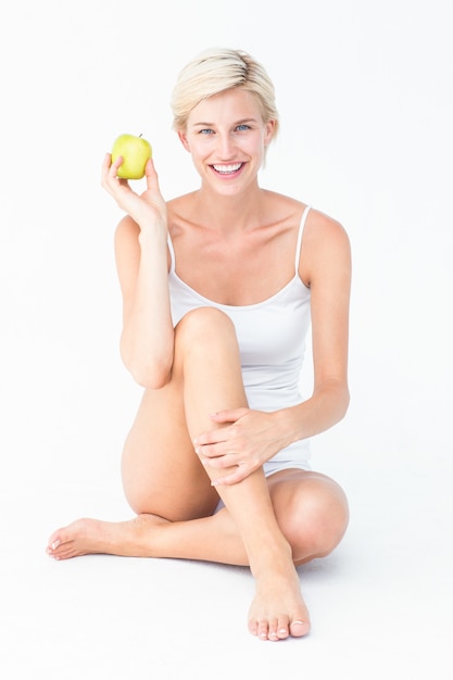 Sitting woman holding an apple 