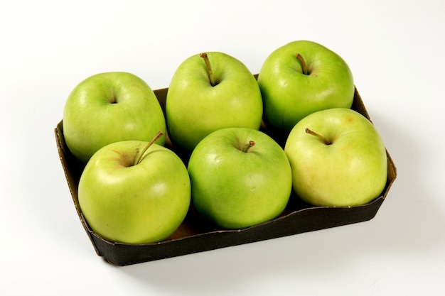 Six green apples in a packing box on a white background