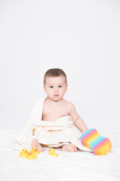 Bambino di sei mesi che indossa un asciugamano dopo il bagno concetto di cura dell'infanzia e del bambino