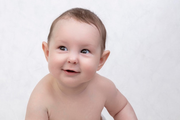 Six month old baby on a white background Happy boy midrange