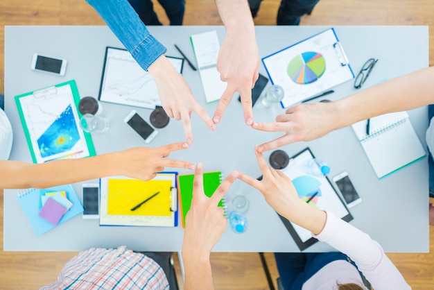 The six people gesture at the desktop. view from above