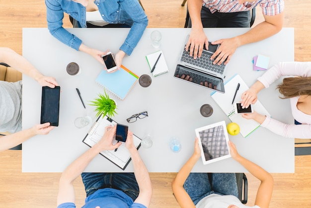 The six people work with devices at the desktop. view from above