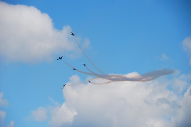 Six planes fly apart at an air show in summer with a lot of fog