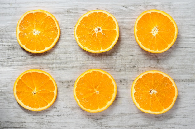 Six slices of fresh oranges on white wood