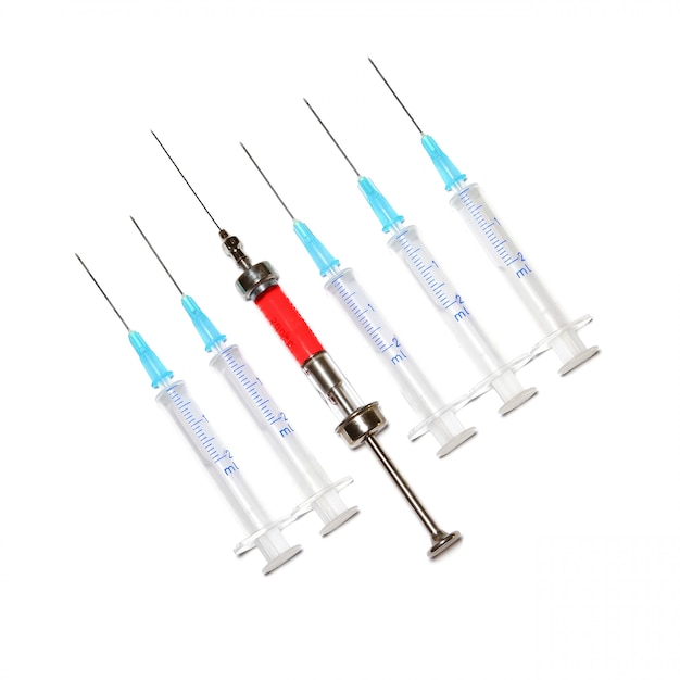 Six syringes in row on white background