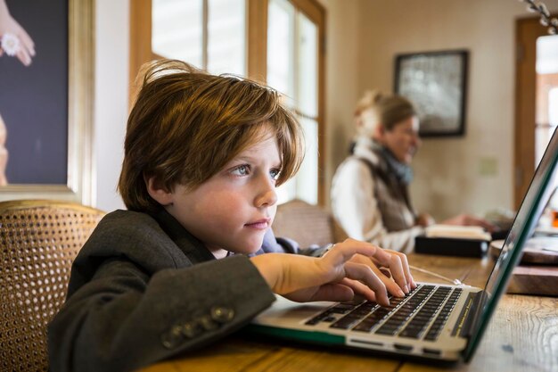 Шестилетний мальчик печатает дома на ноутбуке