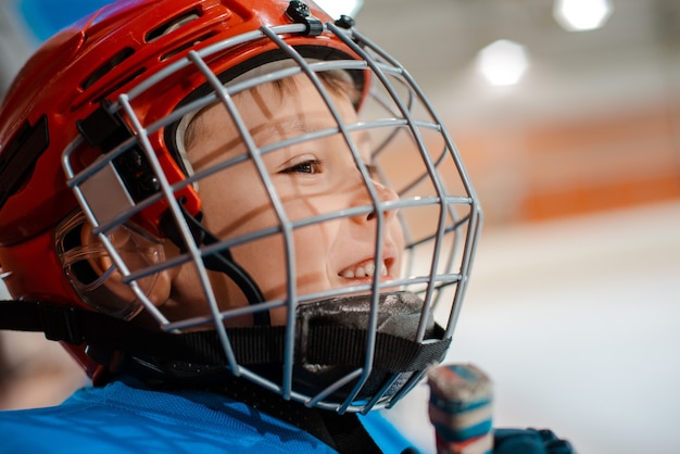 Giocatore di hockey del bambino di sei anni in casco