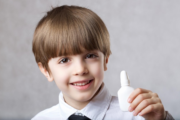 Six years old boy with nasal spray. Closeup