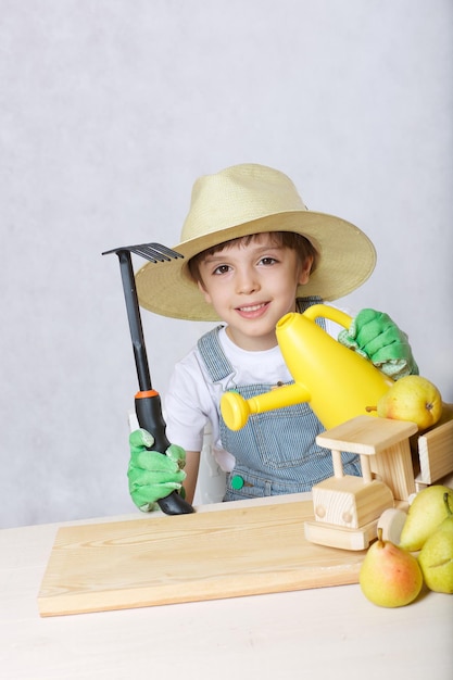 Bambino di sei anni vestito da giardiniere. avvicinamento