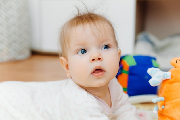 A sixmonthold baby plays on the floor with colorful toys The baby learns to crawl portrait of a 6 month old baby