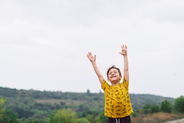 A sixyearold boy runs in the countryside Happy child boy laughing and playing in the summer day