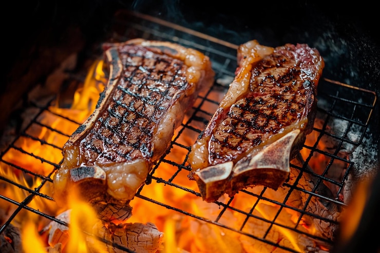 Foto sizzling steak grillen over gloeiende kolen bij schemering bijeenkomst