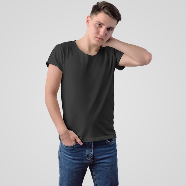 Sjabloon van een zwart T-shirt op een jonge man in spijkerbroek, staand gezicht, op een witte achtergrond. Mockup van modieuze herenkleding voor het gebruik van uw ontwerp en reclame in de online winkel