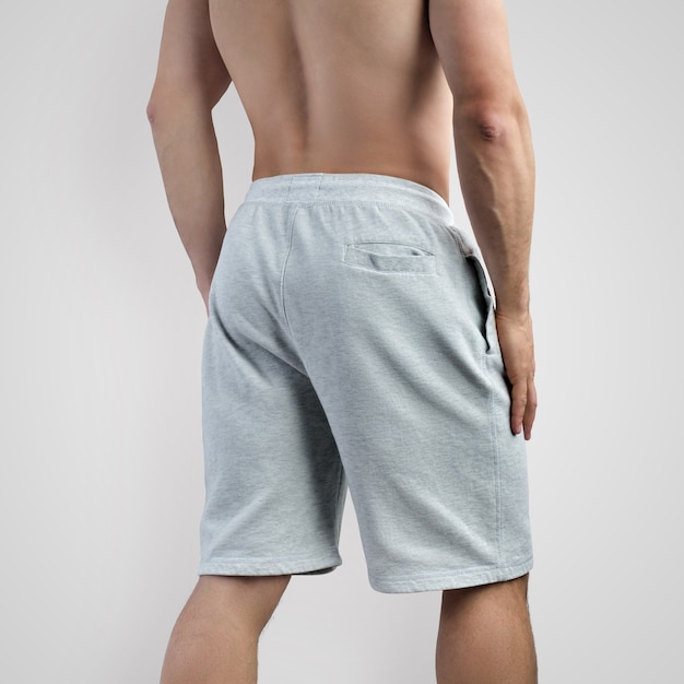Sjabloon van witte shorts op een jonge man op een geïsoleerde achtergrond voor reclame in een online winkel, vooraanzicht. Mockup van herenkleding voor ontwerppresentatie.