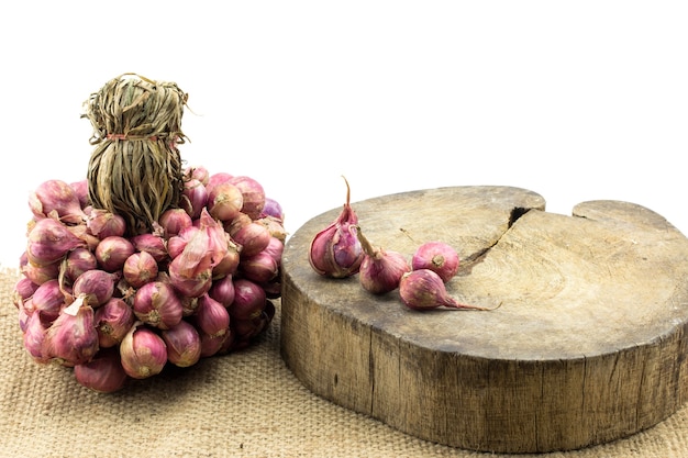 Sjalot uien een groep op oud hout en geïsoleerd op een witte achtergrond