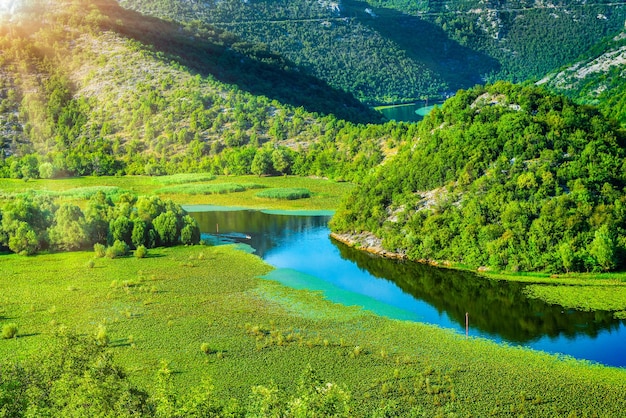 햇빛 아래 몬테네그로 산의 Skadar 호수