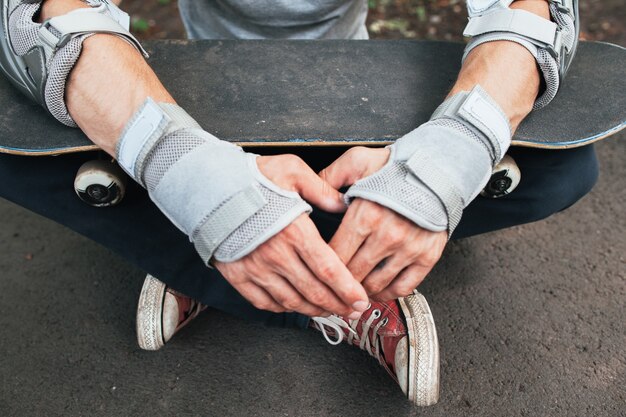 Skateboard halmet, elleboog en handschoenen bescherming op onherkenbare skateboarder.