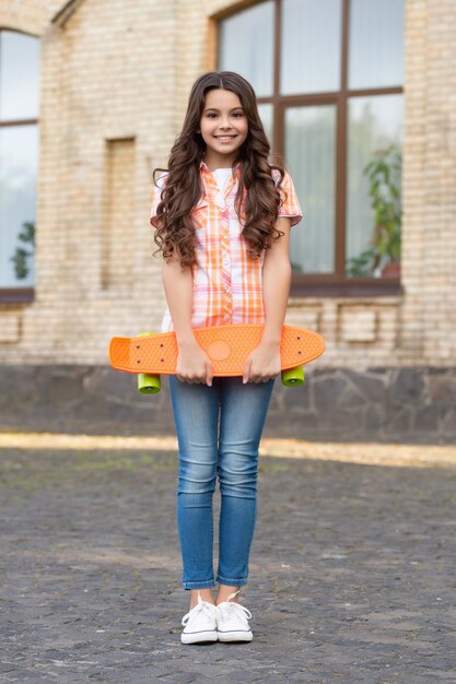 Skateboarden van lachend tienermeisje op straat foto van tienermeisje skateboarden