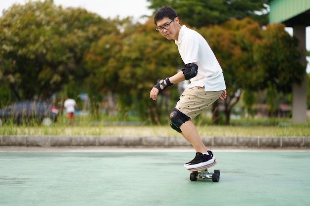 skateboarder Aziatische man met plezier met skateboard rond stadsstraten op een zomerdag.