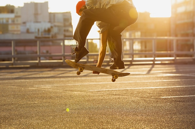 Skateboarder doet een truc in de straat van de stad in de zomerzon