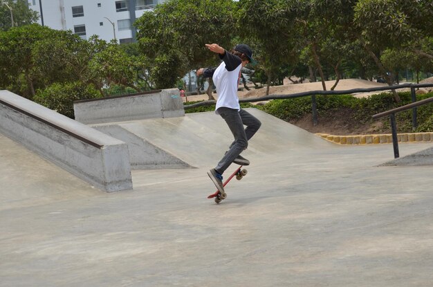 Foto uno skateboarder sta facendo un trucco in un skate park