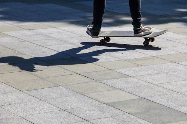 Skateboarder legs riding skateboard at skatepark