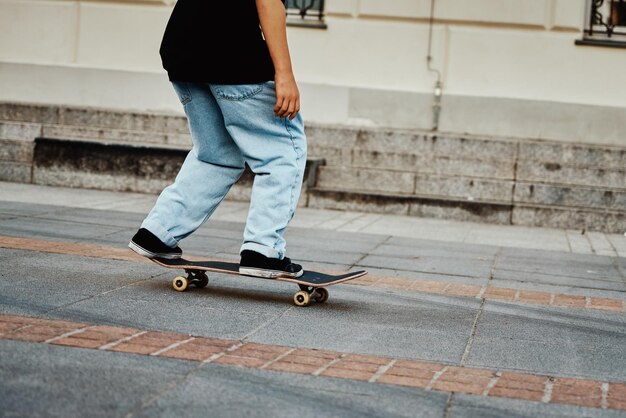 写真 スケートボーダーが街の通りでスケートボードに近づいている